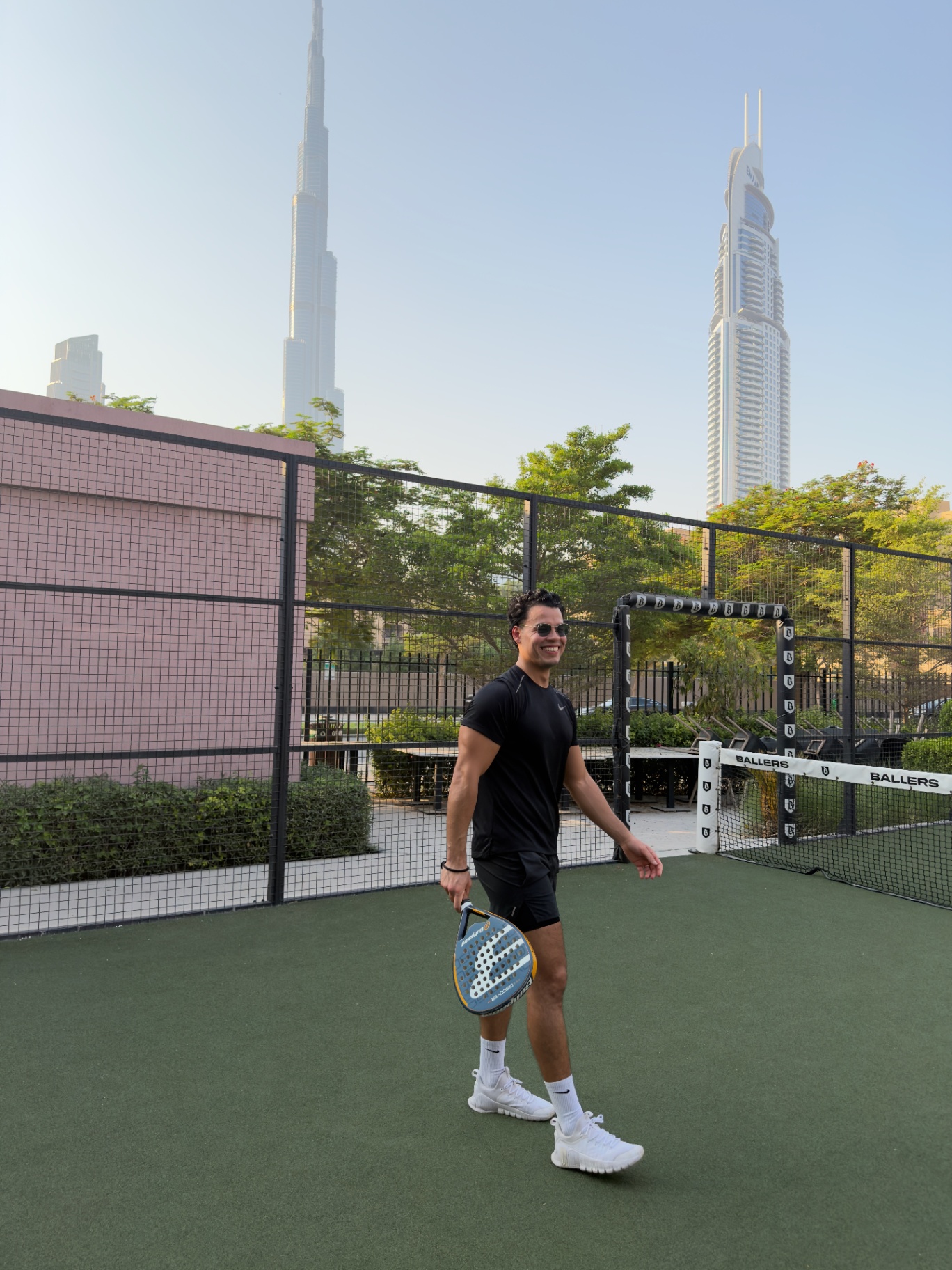 Padel player holding a racket beneath the Dubai skyline